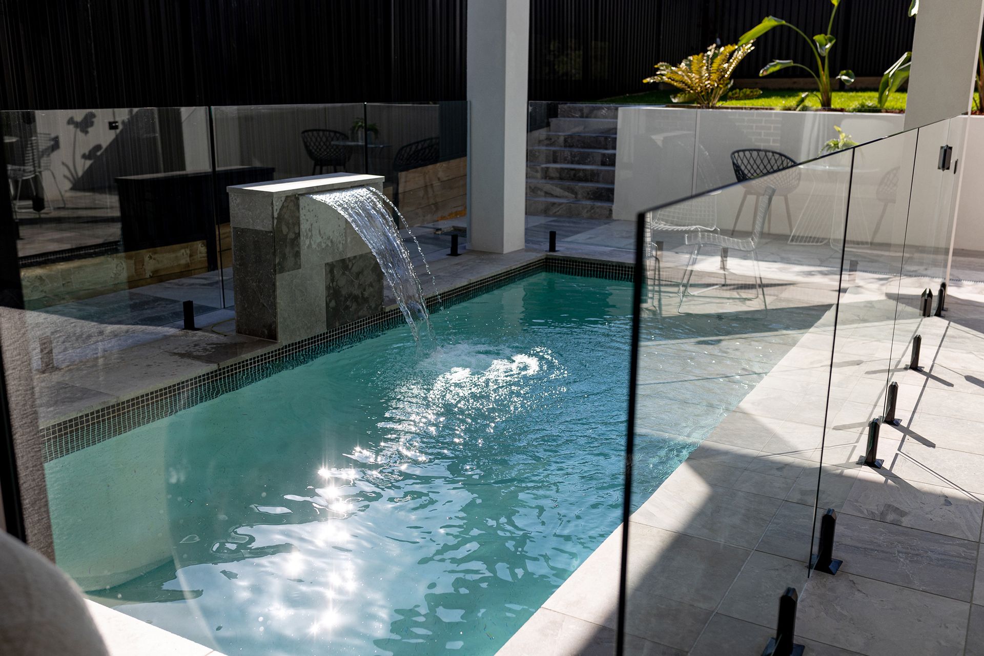 There is a glass fence in the side of the pool.