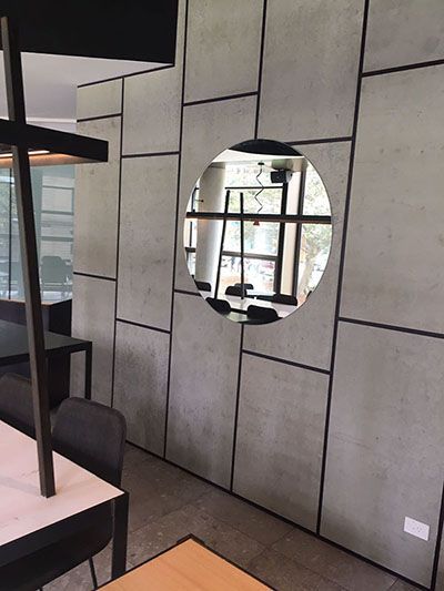 A dining room with a round mirror on the wall