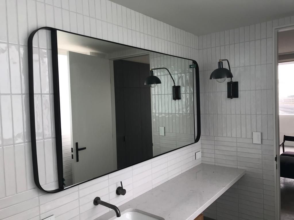 A bathroom with a large mirror and a sink.