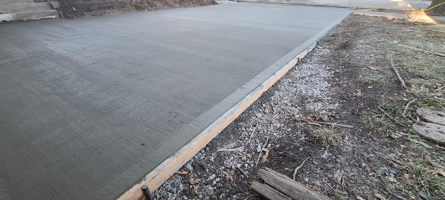 A man painting a concrete wall with a roller brush.