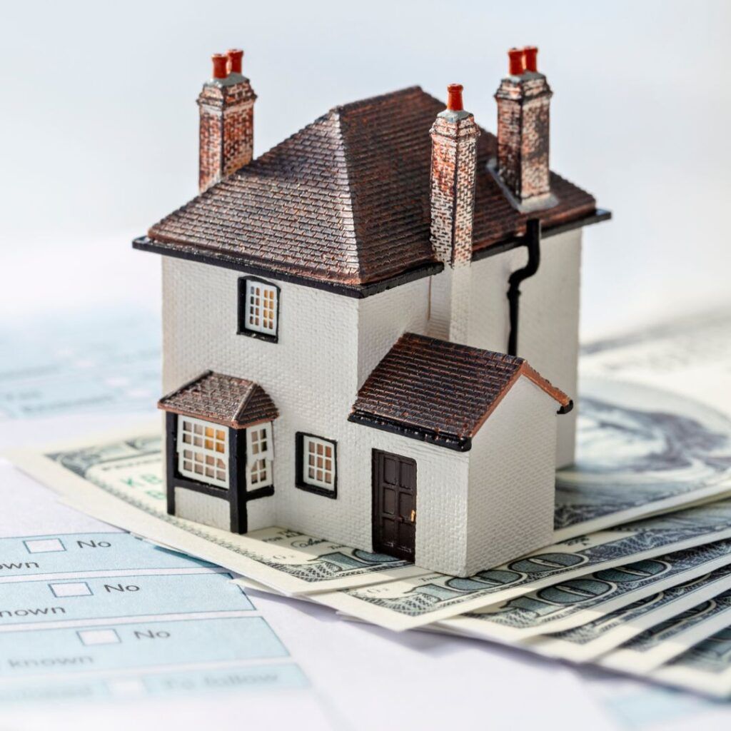 Model house on top of money and a form.