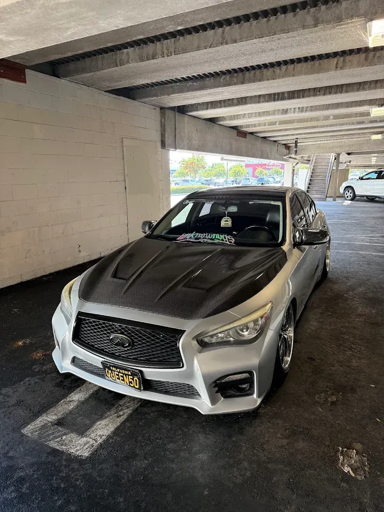Silver sedan parked in a covered parking garage, front view.
