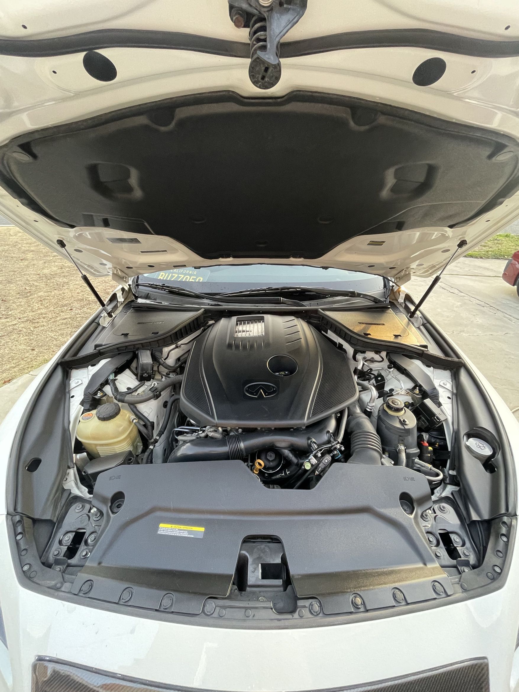 Open car hood showing a clean engine bay in a white vehicle