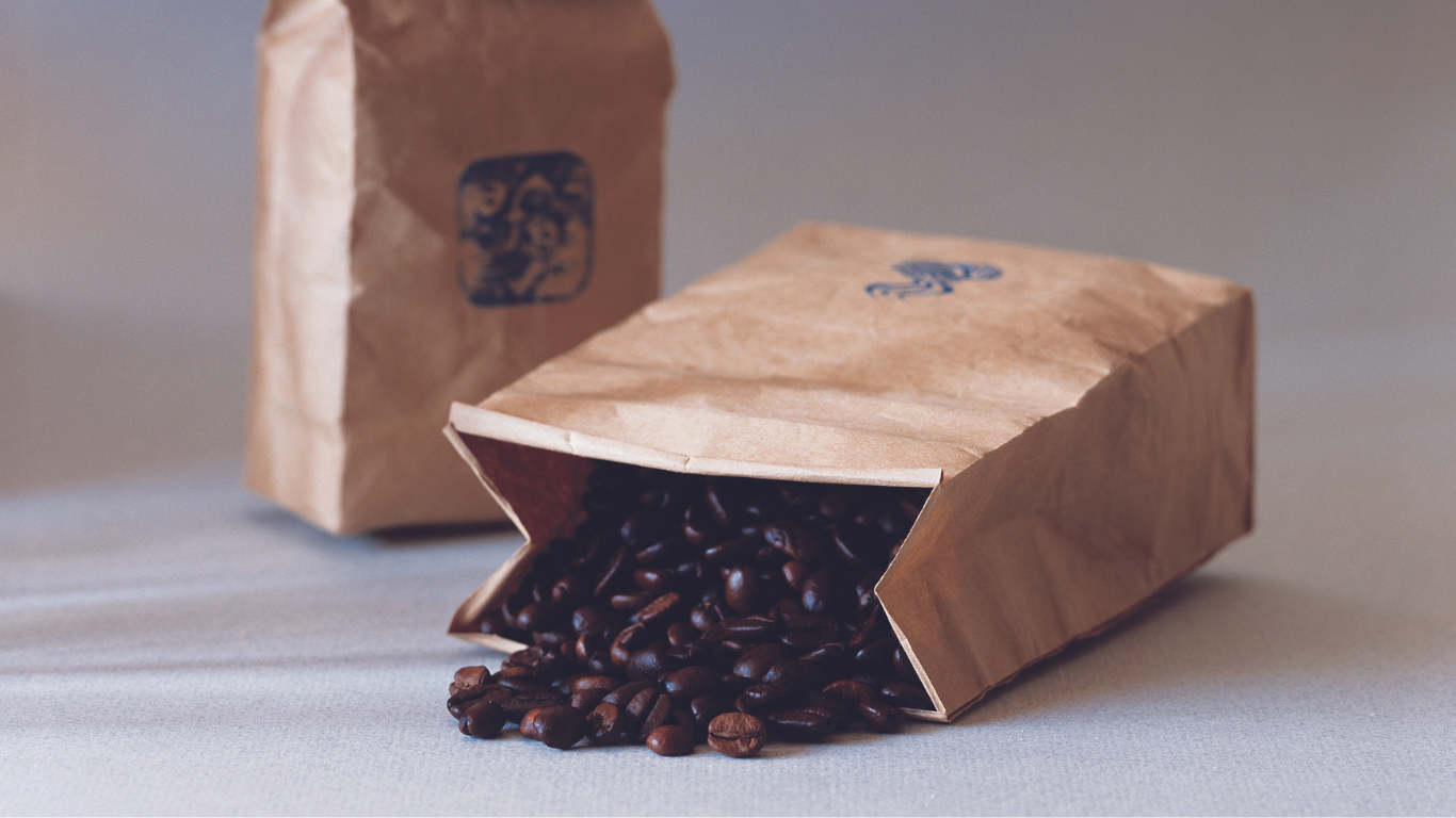 four paper cups of coffee are sitting on a wooden tray .