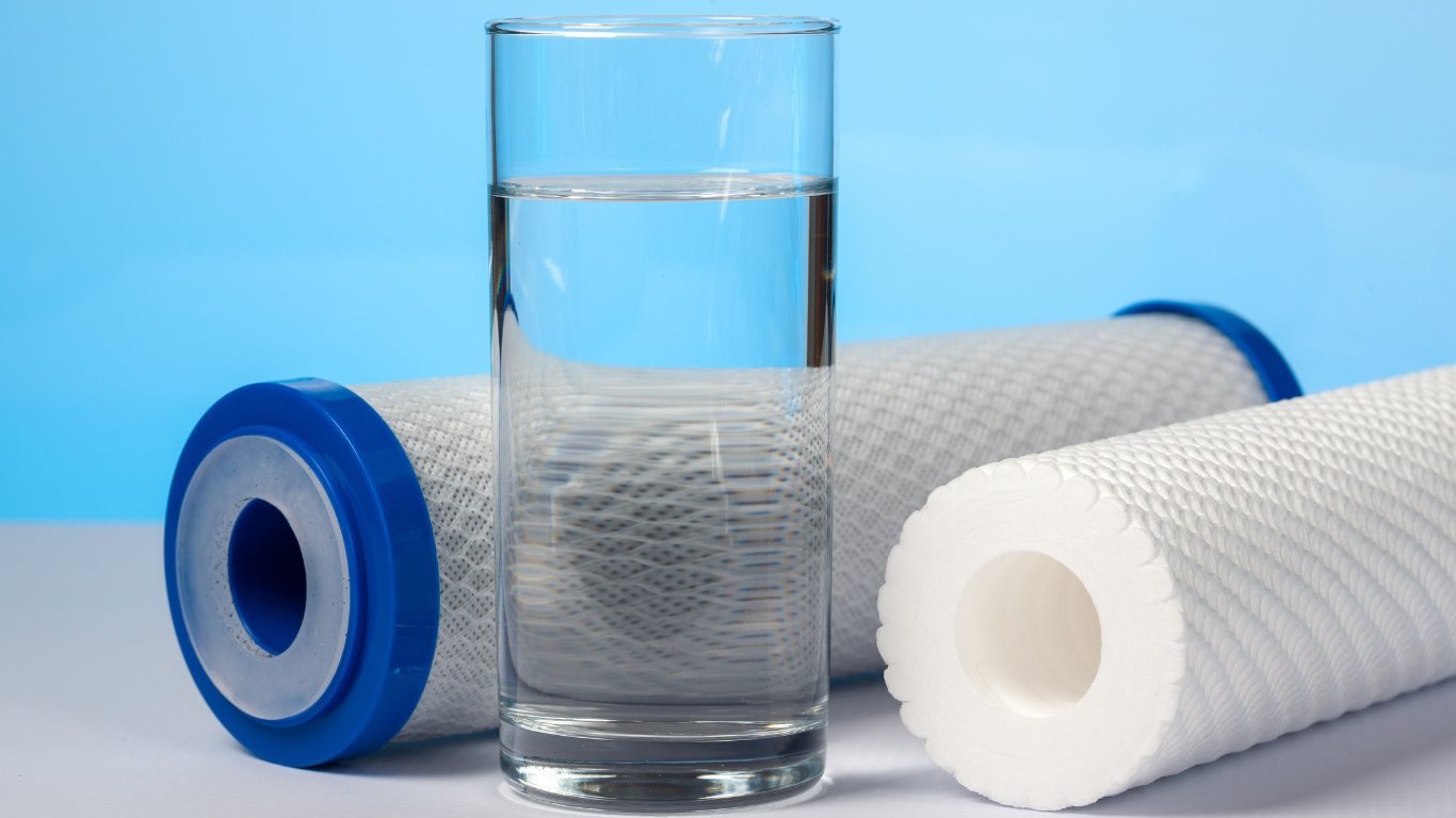 a person is holding a water filter in front of a sink .
