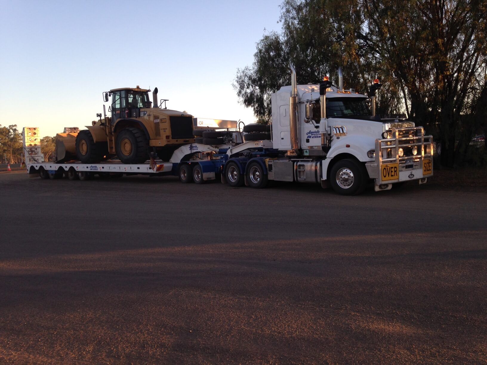 A semi truck is carrying a bulldozer on a trailer.