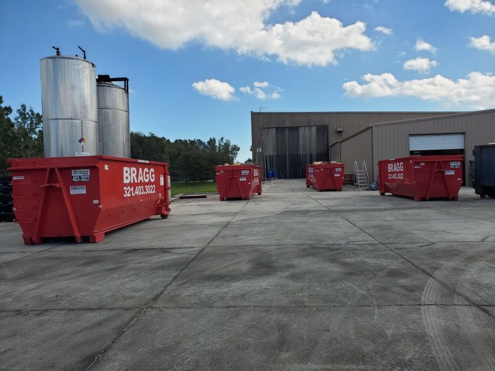 Dumpsters Outside a Warehouse — Melbourne, FL — Braggs Roll-Off Dumpsters Inc.