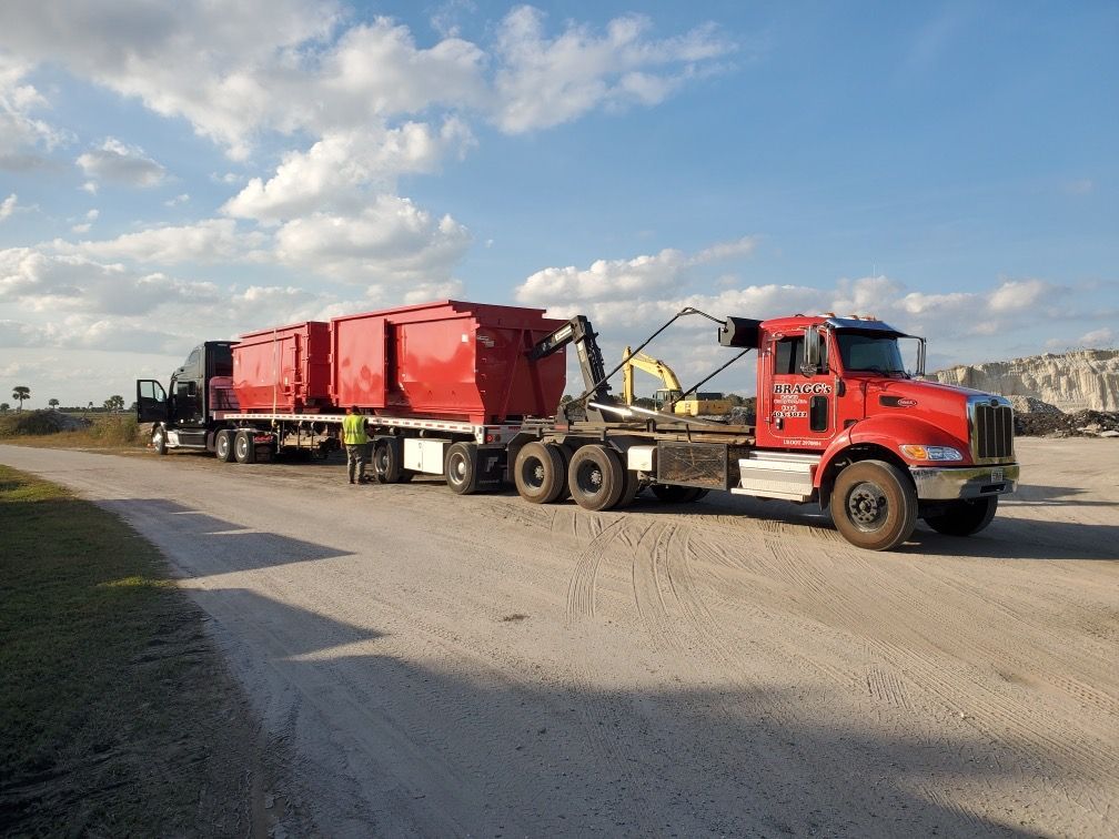 Dumpster Truck and Dumspters on a Flatbed Truck — Melbourne, FL — Braggs Roll-Off Dumpsters Inc.