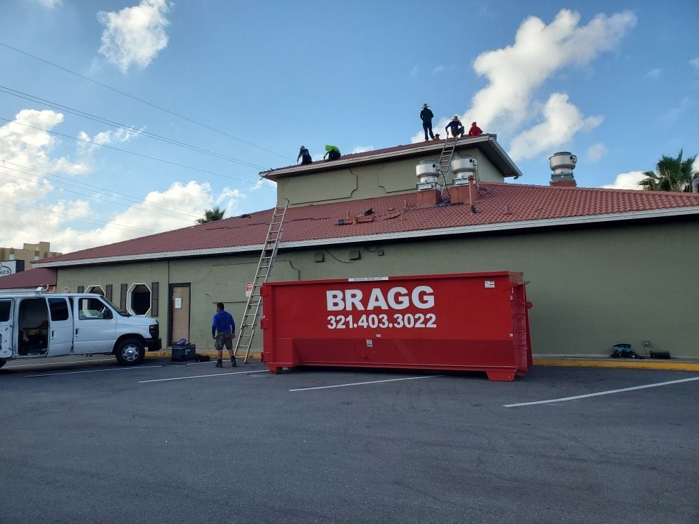 Dumpster And Workers — Melbourne, FL — Braggs Roll-Off Dumpsters Inc.