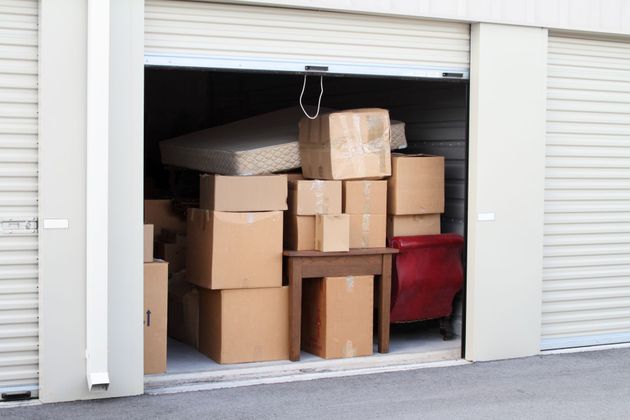 A storage unit filled with cardboard boxes and a mattress
