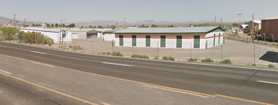 A building is sitting on the side of a road next to a highway.