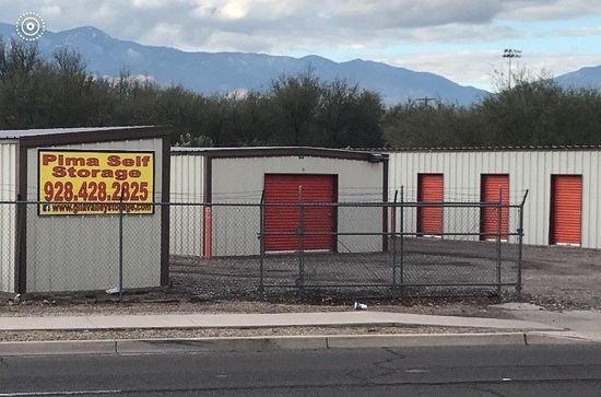 A fenced in area with a sign that says prime self storage