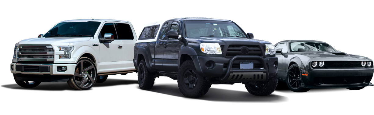 Three vehicles: a white pickup truck, a black pickup truck, and a grey muscle car. | Auto Medics of Missoula