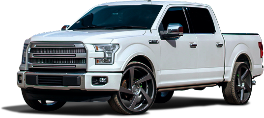 White Ford F-150 pickup truck with large dark rims, parked at an angle. | Auto Medics of Missoula