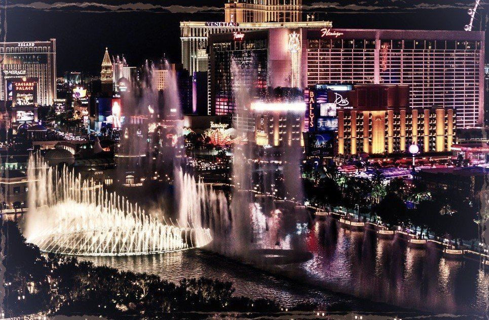 A city at night with a fountain in the foreground