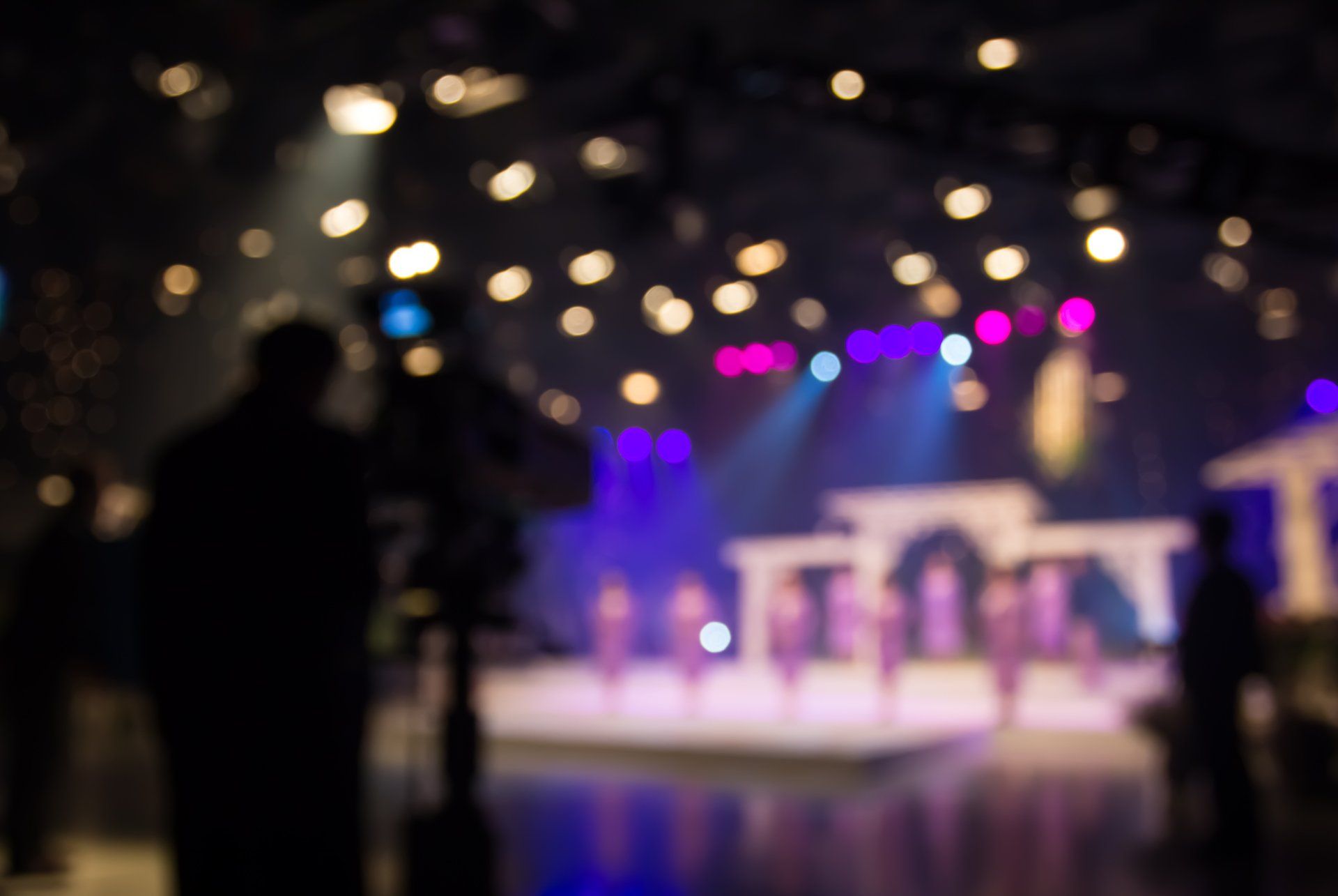 A blurry picture of people standing in front of a stage at a concert.