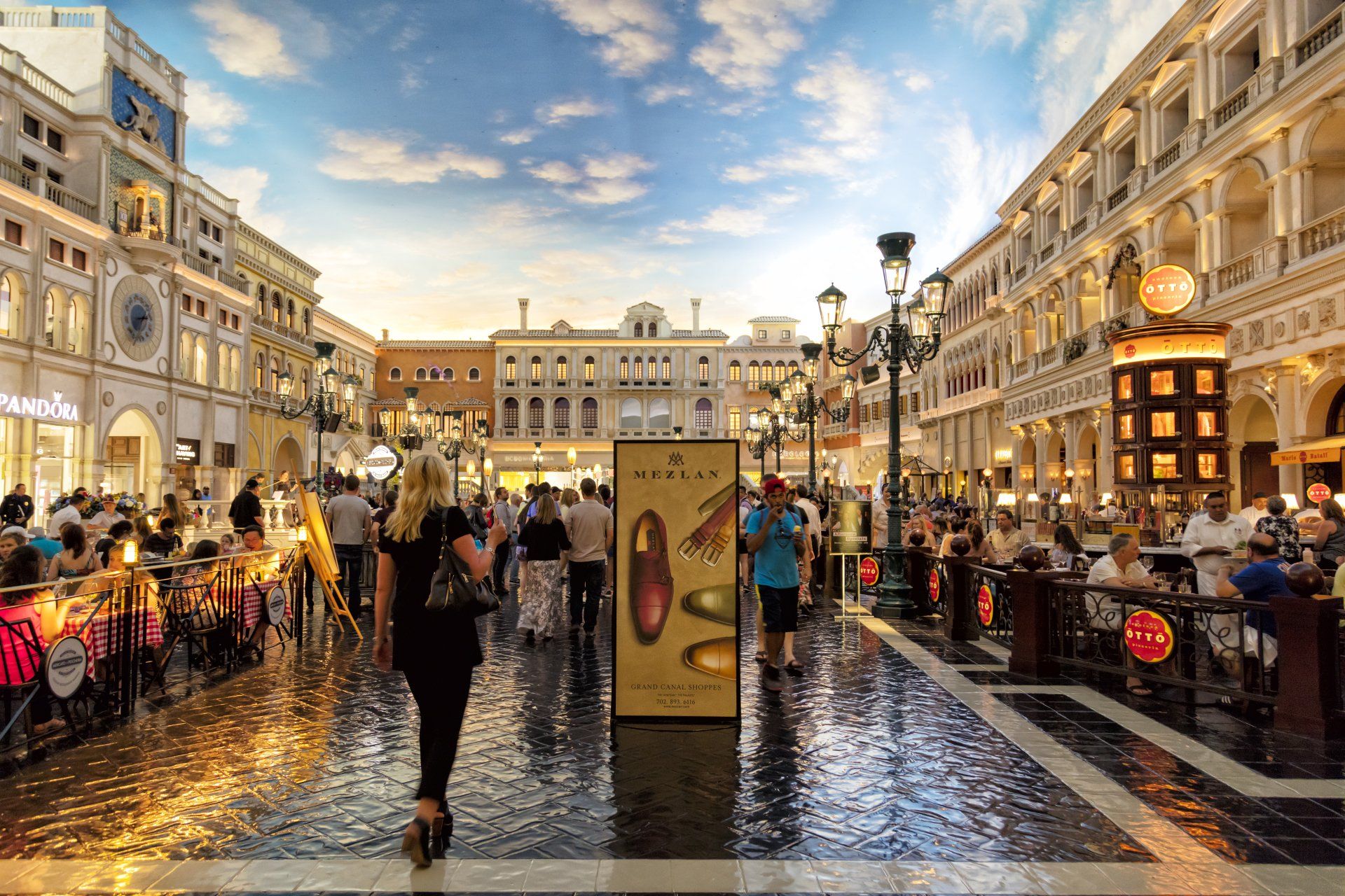 A woman is walking down a busy street in a city.