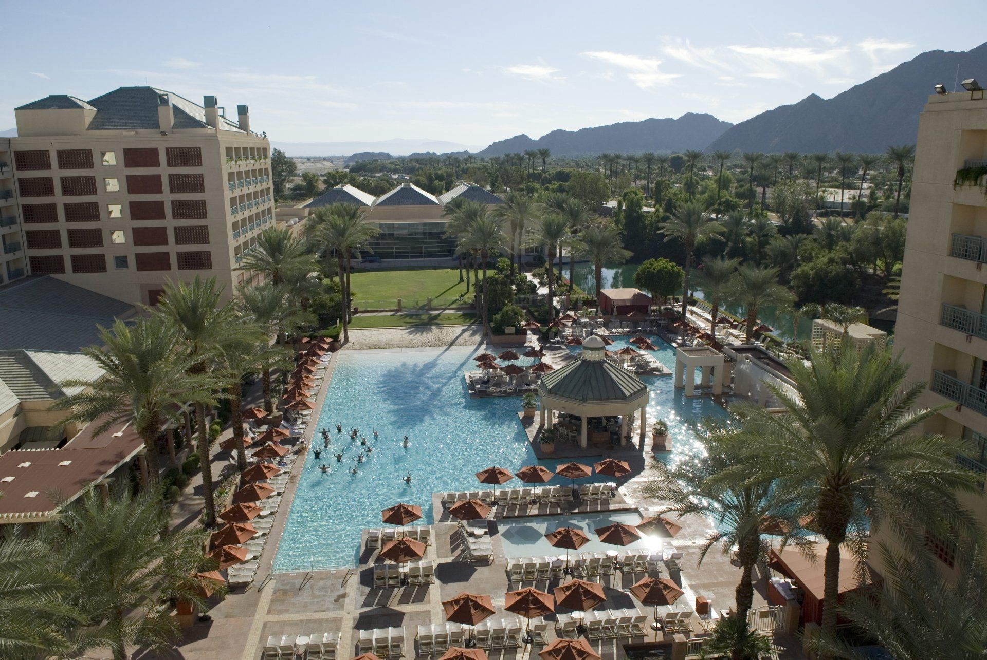 An aerial view of a large swimming pool surrounded by palm trees