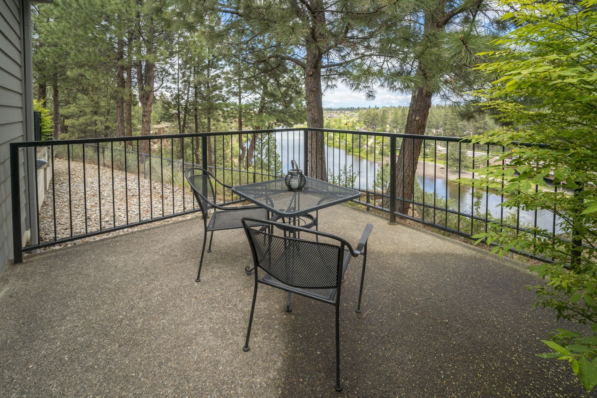 A balcony with a table and chairs overlooking a lake.