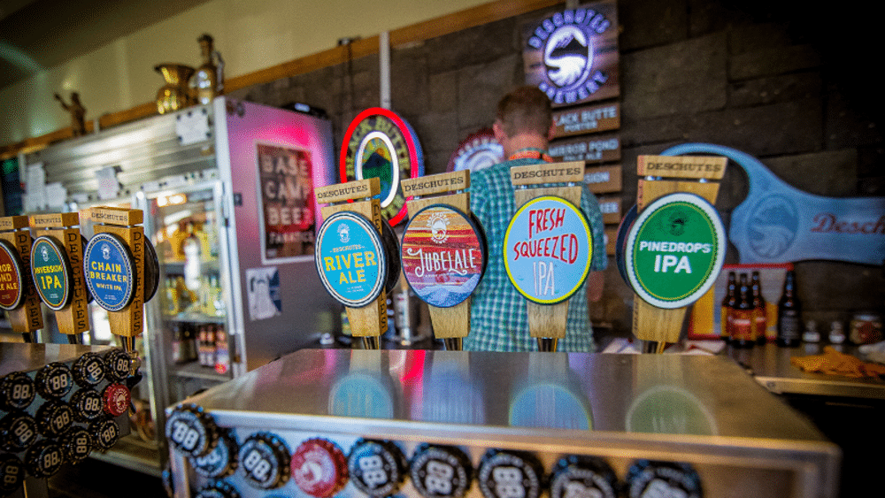 A man is pouring beer from a tap in a bar.