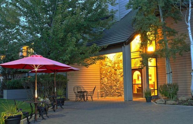 A patio with tables and chairs and umbrellas in front of a building