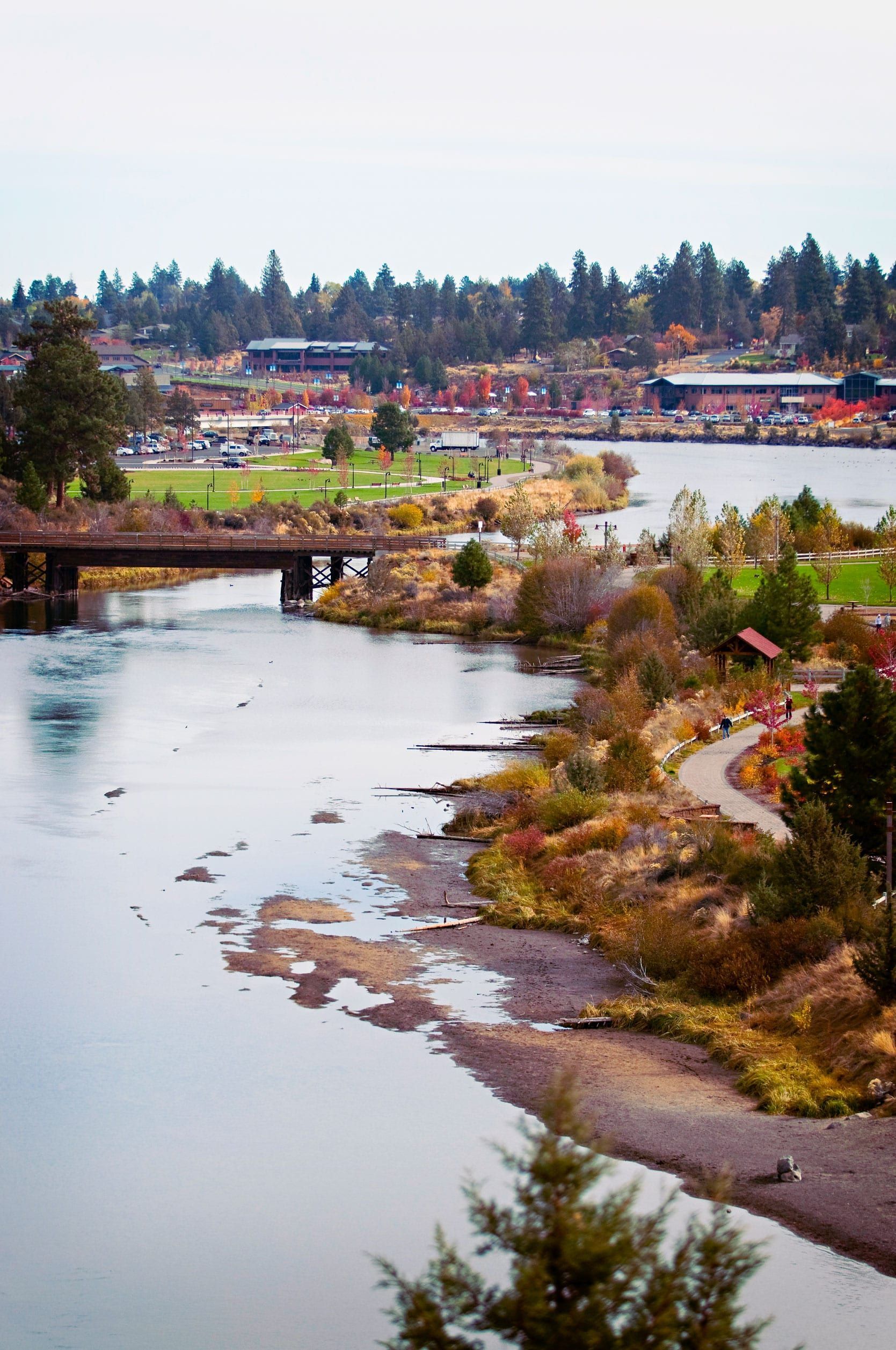 A river with a bridge over it and a city in the background.