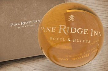 A pine ridge inn hotel and suites logo on a glass ball