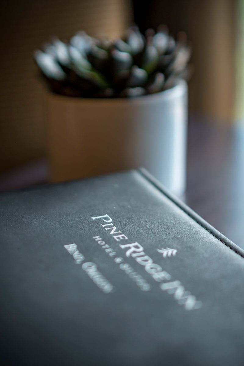 A book is sitting on a table next to a potted plant.
