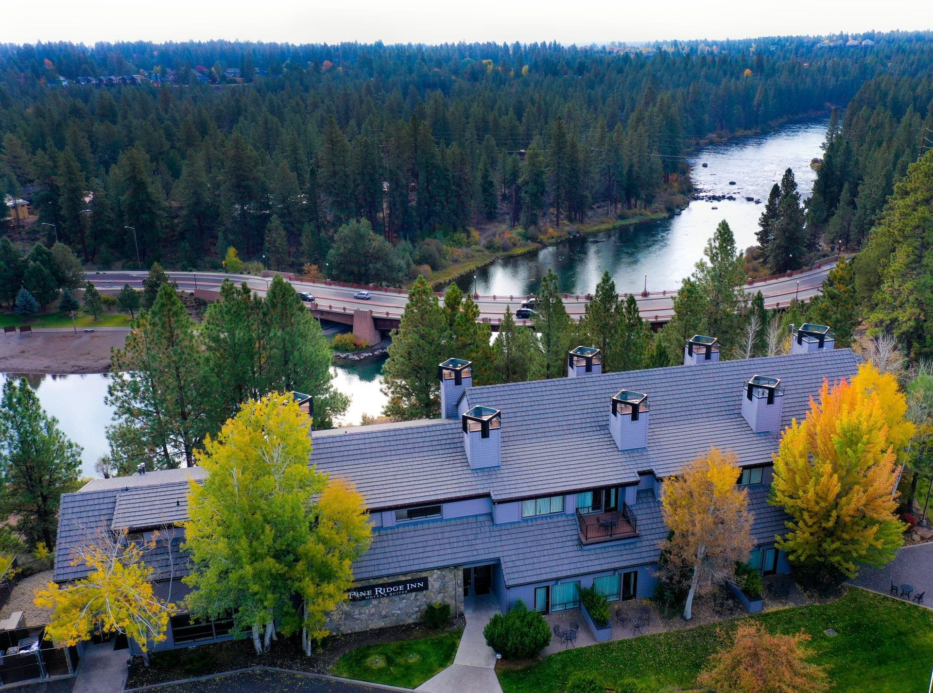 An aerial view of a building with a lake in the background