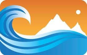 A wave in the ocean with a mountain in the background.