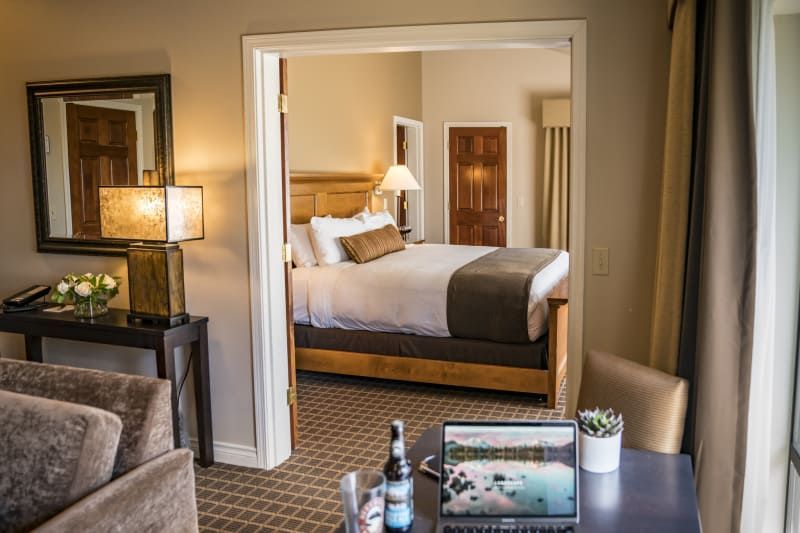 A hotel room with a king size bed and a laptop on a desk.