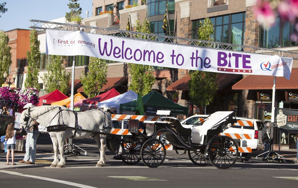 A horse drawn carriage is parked in front of a sign that says welcome to the bite