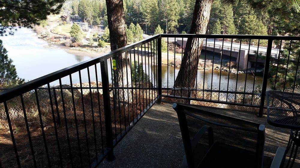 A balcony with a view of a lake and trees