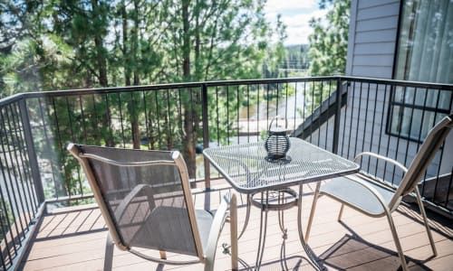 There is a balcony with a table and chairs on it.