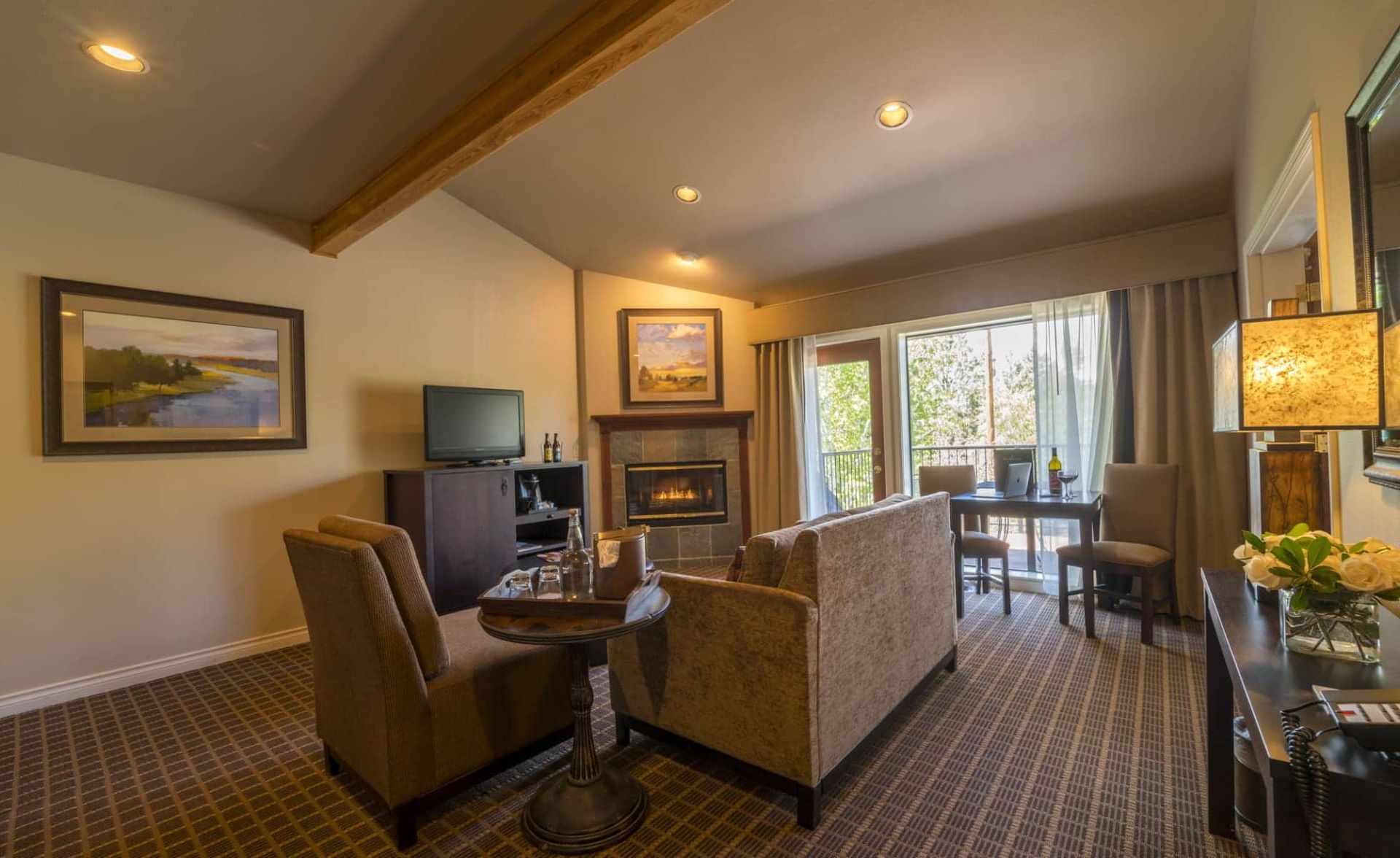 A living room with a couch , chairs , table and fireplace.