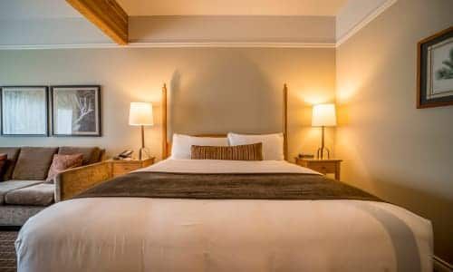 A hotel room with a king size bed and a couch.