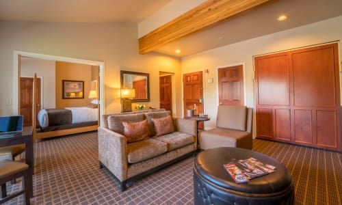 A hotel room with a couch , chairs , and a table.