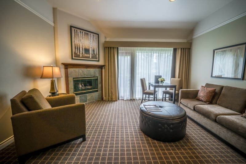 A living room with a couch , chair , table and fireplace.