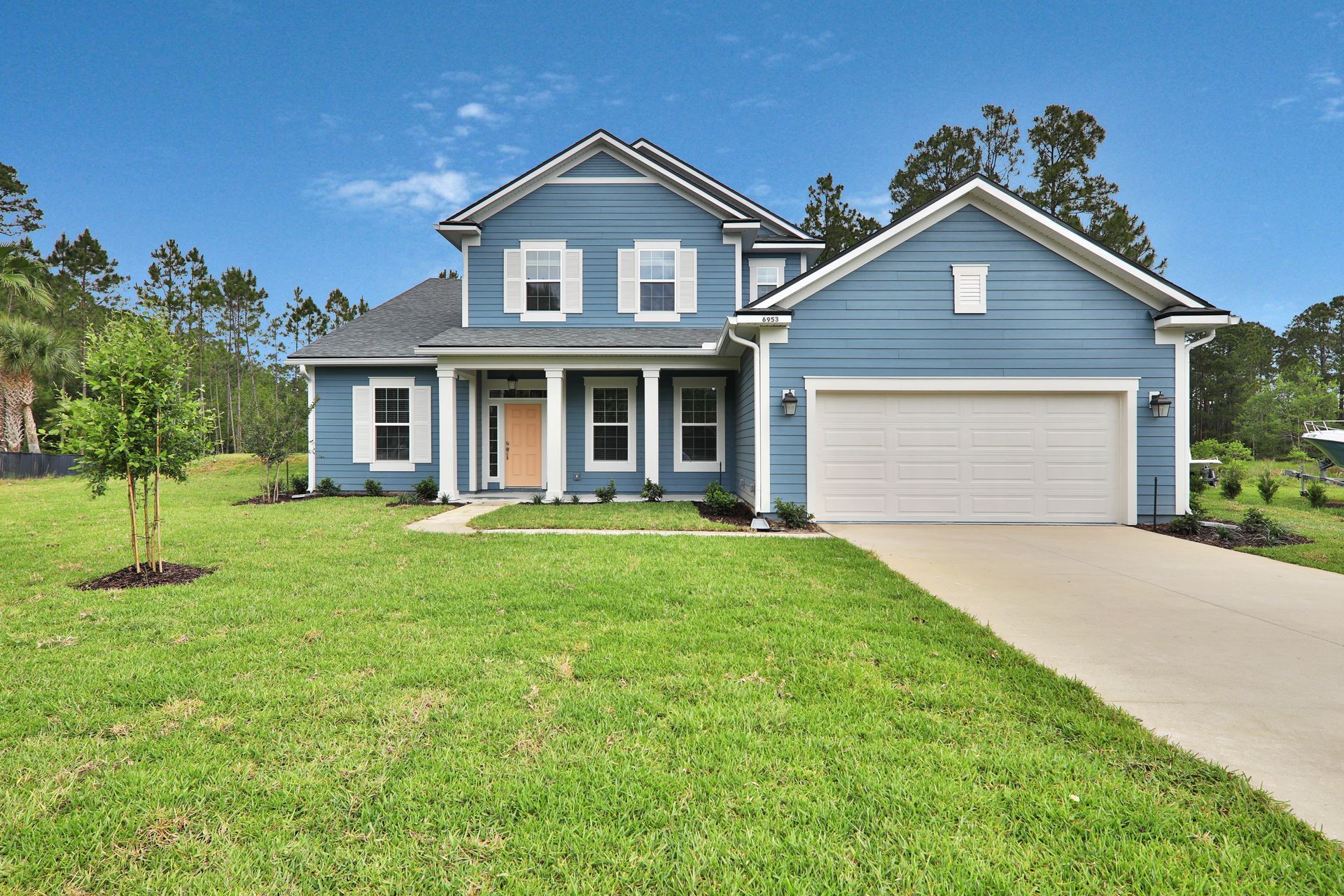 A blue house with white trim and a white garage door