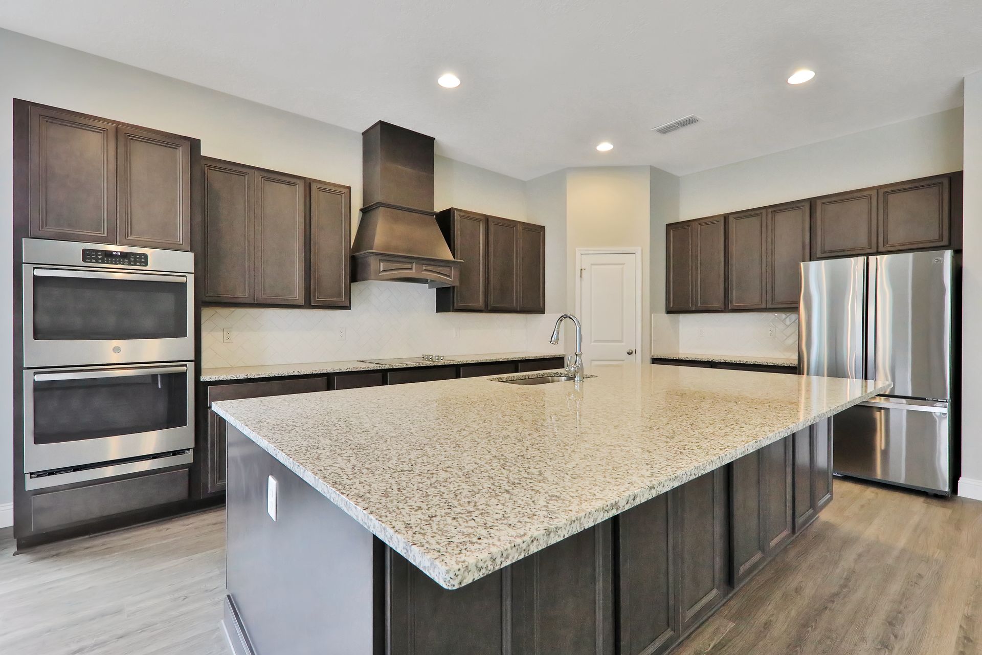 A kitchen with granite counter tops and stainless steel appliances.