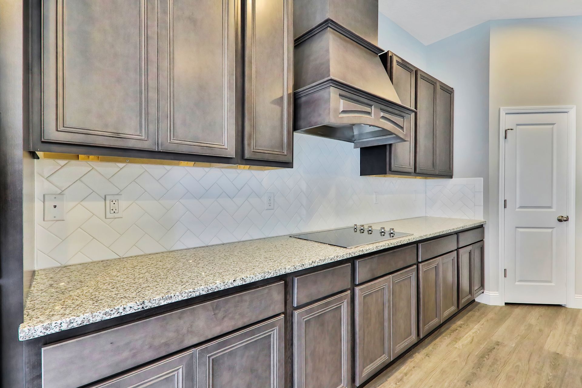 A kitchen with gray cabinets and granite counter tops