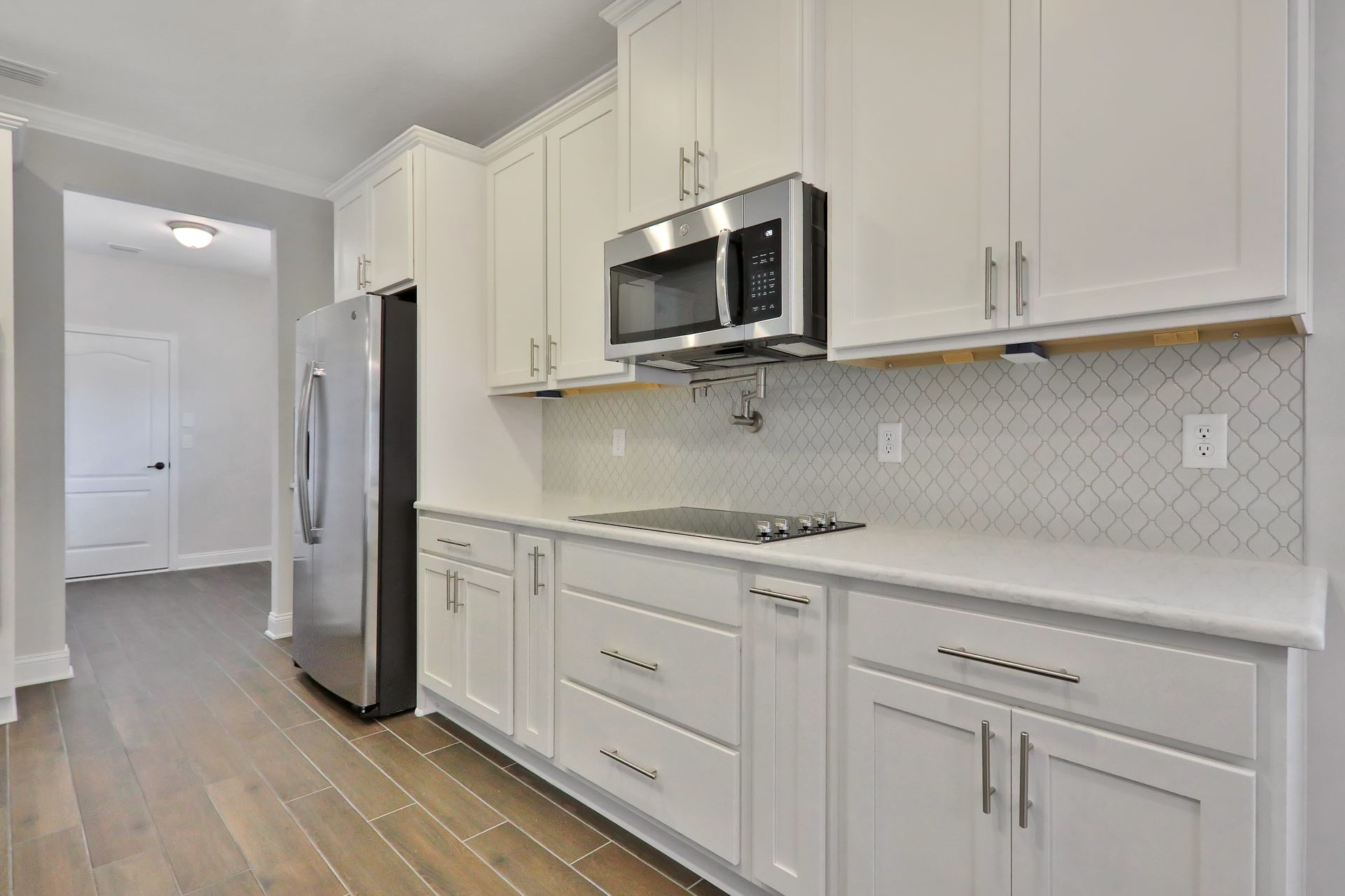 A kitchen with white cabinets and stainless steel appliances.