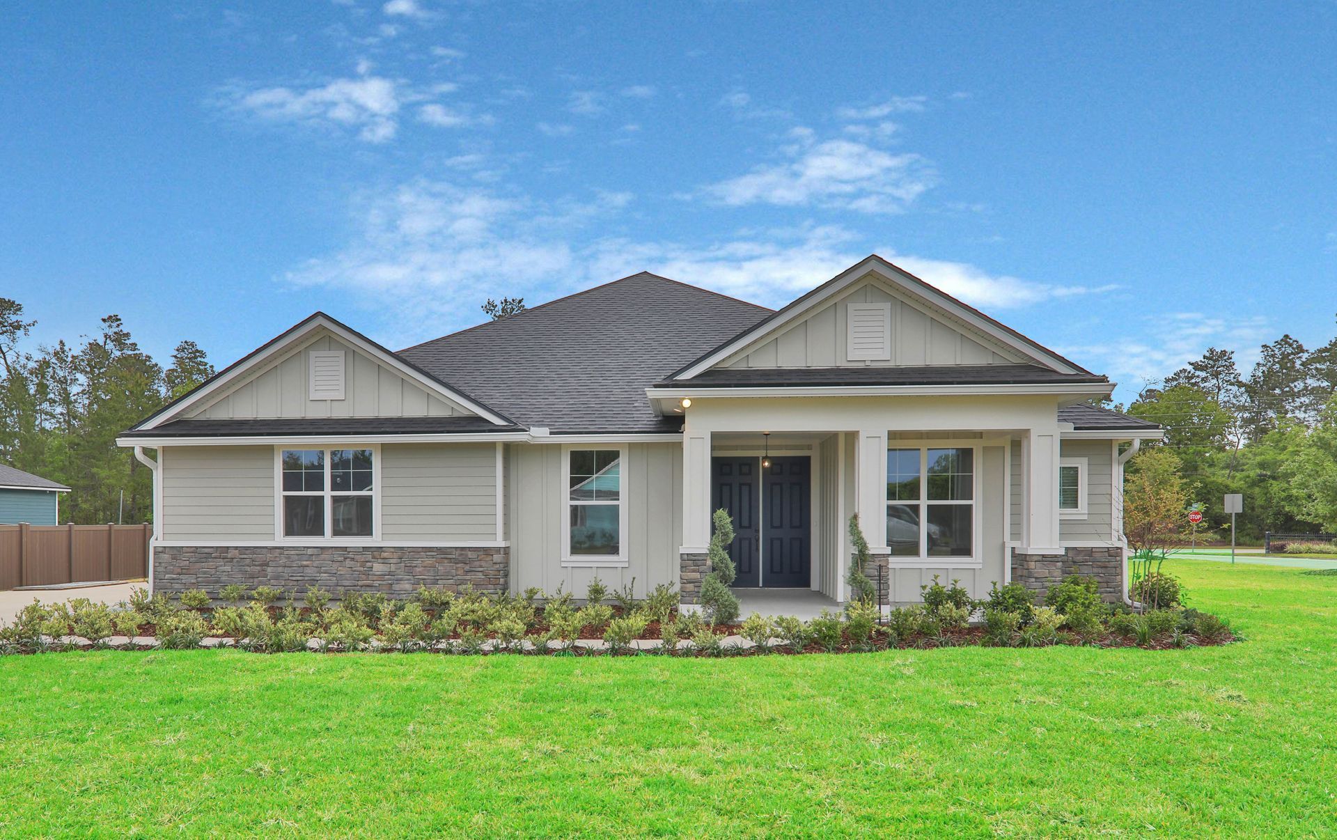 A white house is sitting on top of a lush green lawn.