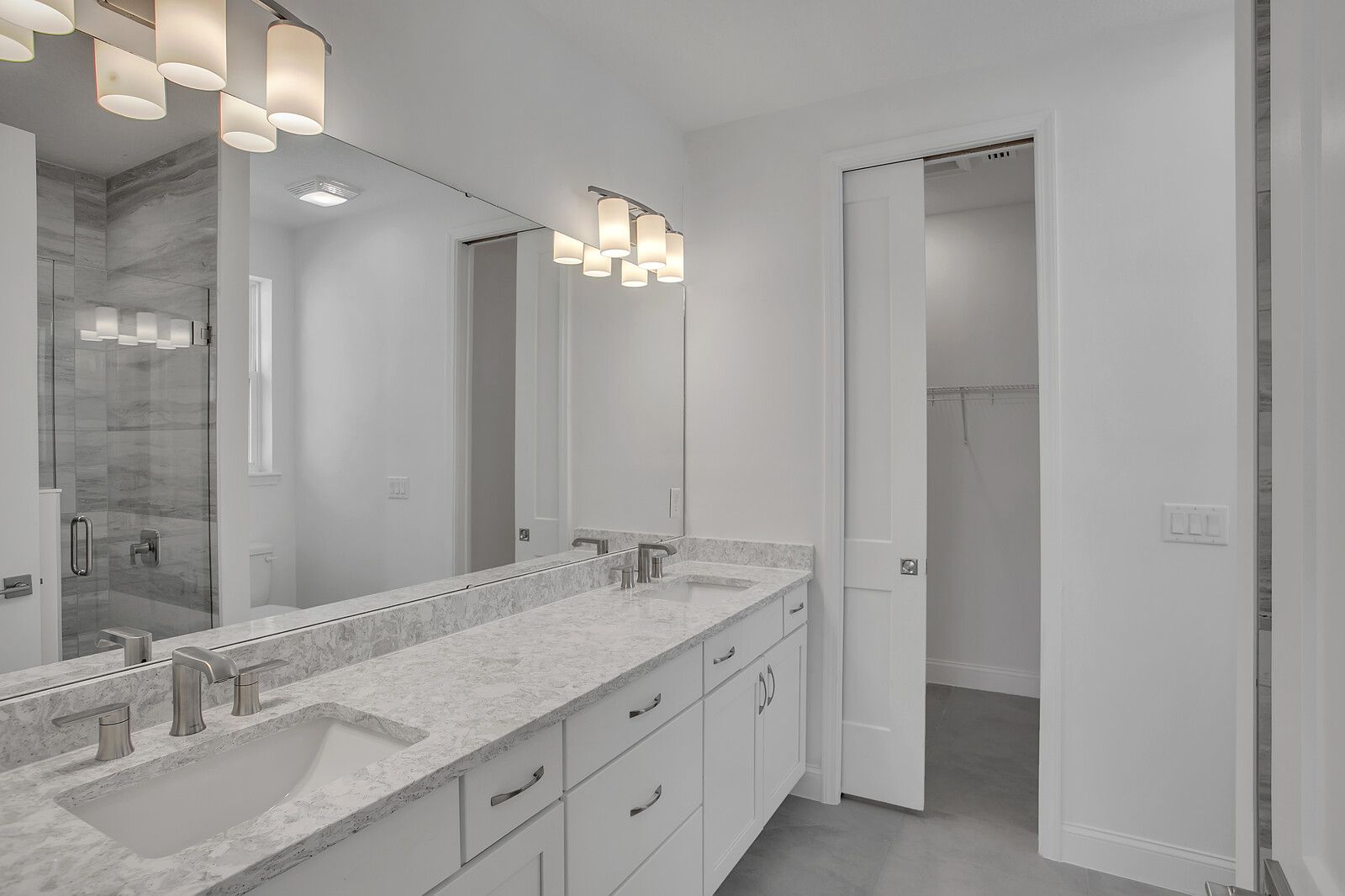 A bathroom with two sinks and a large mirror.