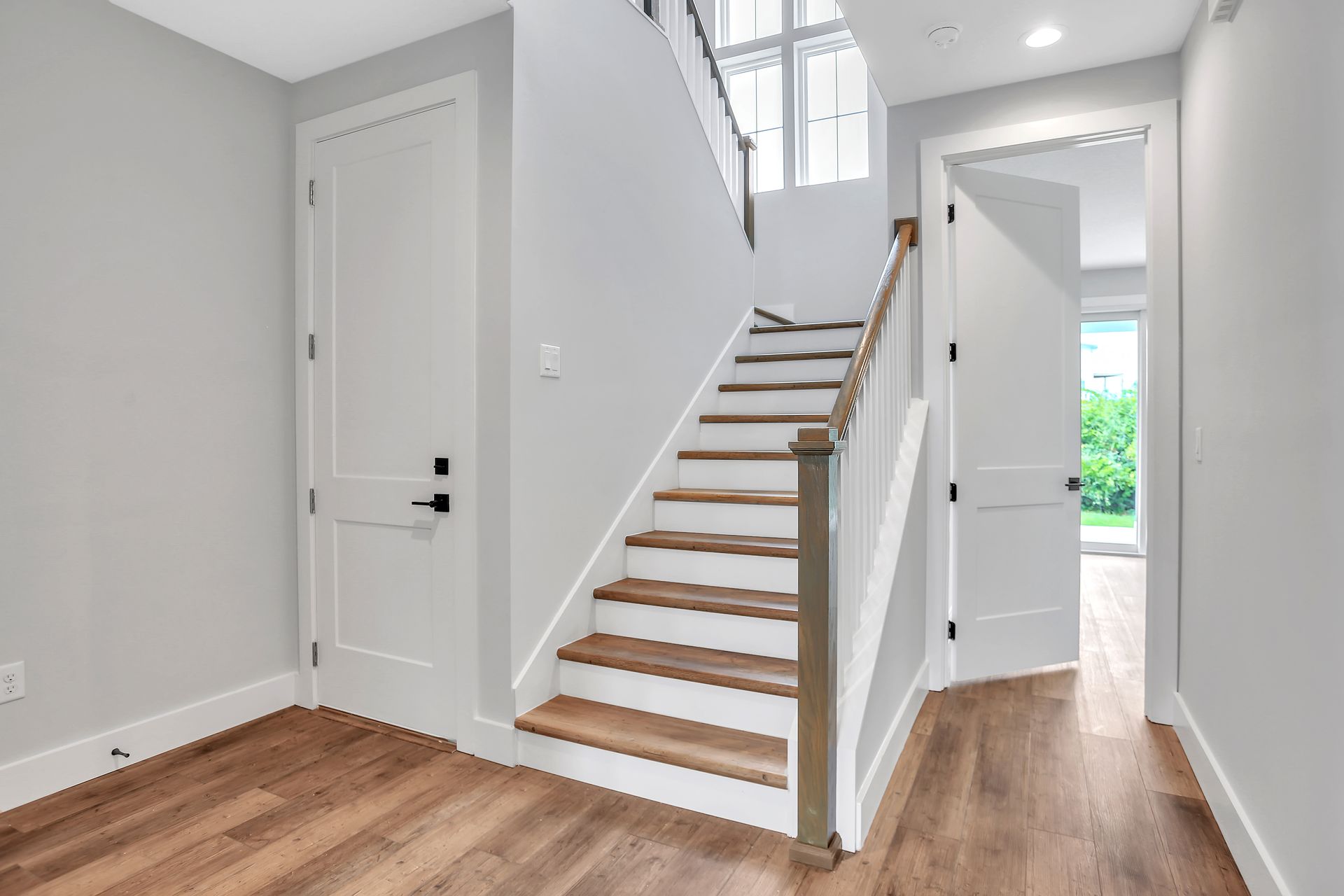 A hallway with stairs leading up to the second floor of a house.