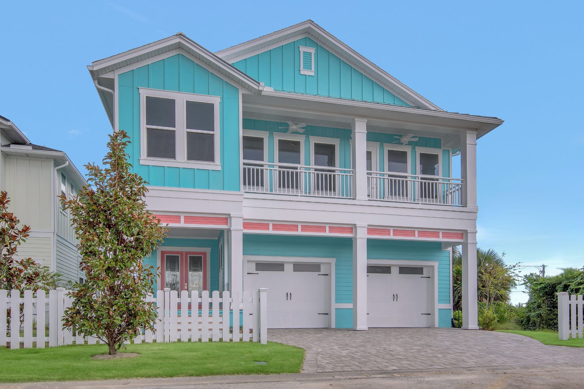 A large blue house with a white fence in front of it