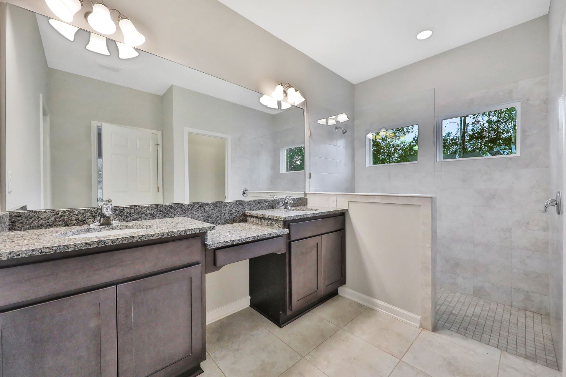 A bathroom with two sinks and a walk in shower