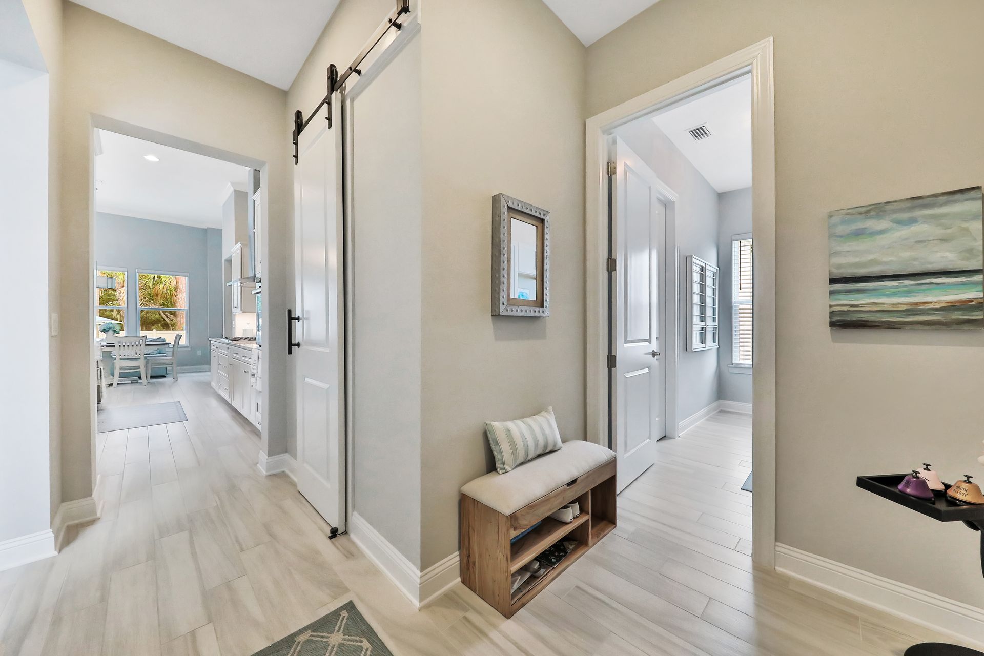 A hallway with a bench and a painting on the wall.