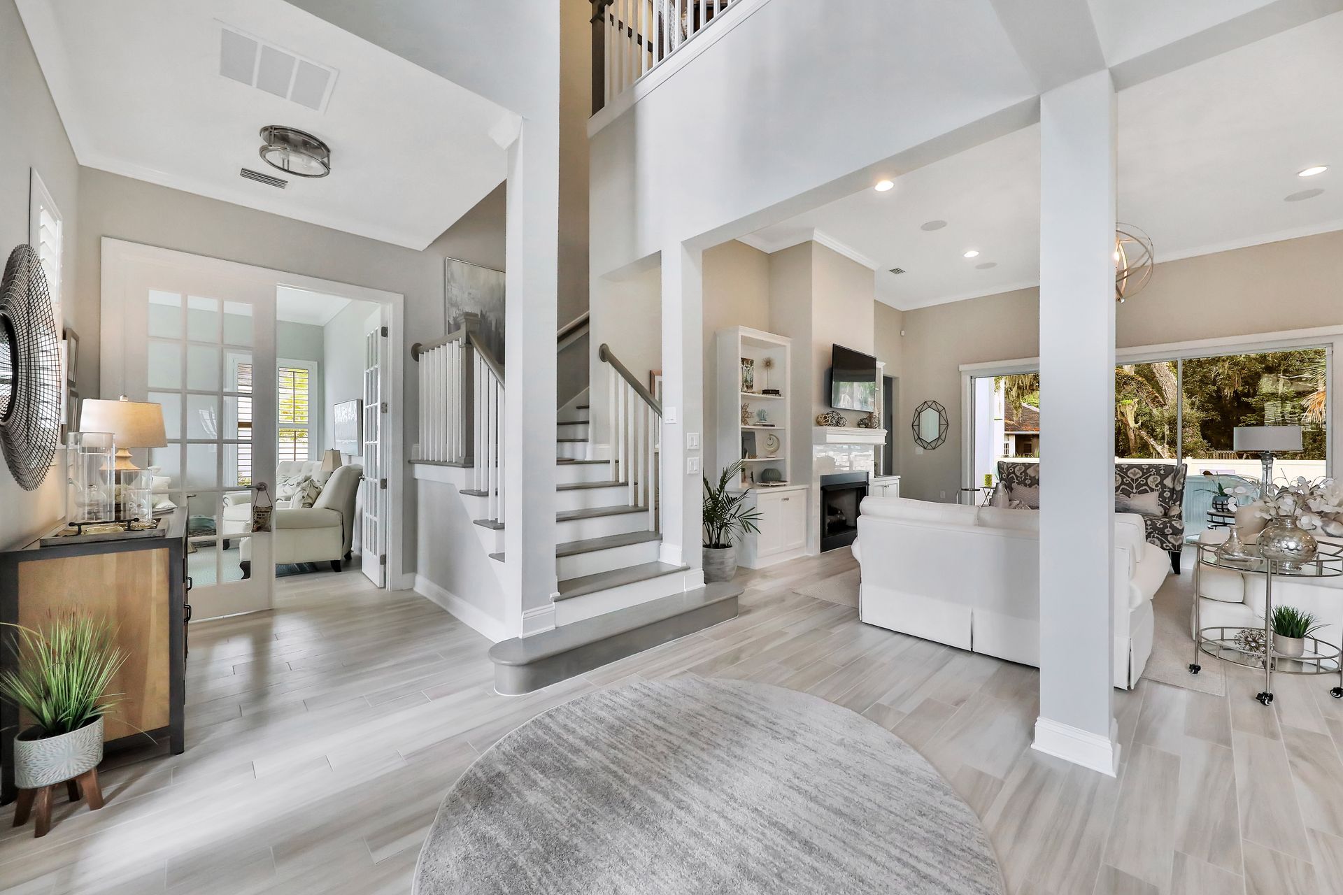 A living room with a staircase leading up to the second floor.