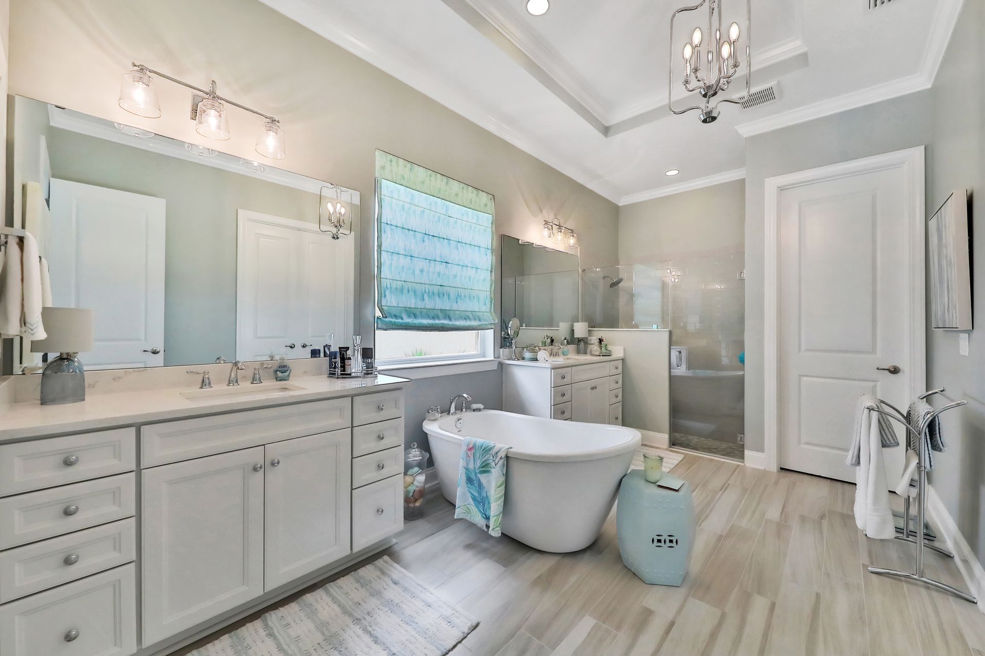 A bathroom with a tub , sinks , mirrors and a window.